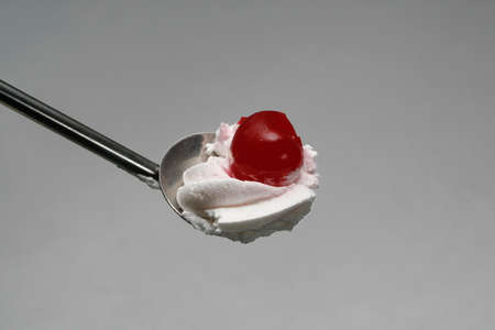 marachino cherry and whipped cream on a teaspoon.の写真素材