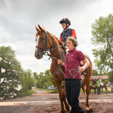 Magdeburg, Germany - 24 June 2017: Assistant leads the horse behind the bridle to the hippodrome. Before the start. Race track in Magdeburgのeditorial素材