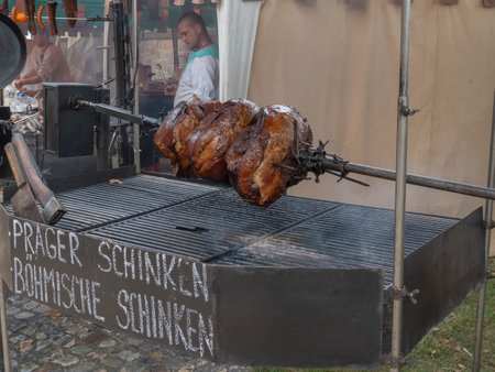 Meat is skewered on a spit, medieval delights. Reconstruction of historical events of the city Magdeburg, Germany. The Kaiser-Otto-Fest for the whole familyのeditorial素材