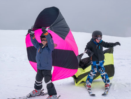 Zams, Austria - 22 Februar 2015: Children in ski school. Ski resort. Boys learning to ski and practicing the correct moves. Colorful butterflies on the snowのeditorial素材