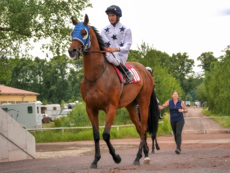 Magdeburg, Germany - 24 Juni 2017: Jockey rides on the red horse to the hippodrome. Race track in Magdeburgのeditorial素材