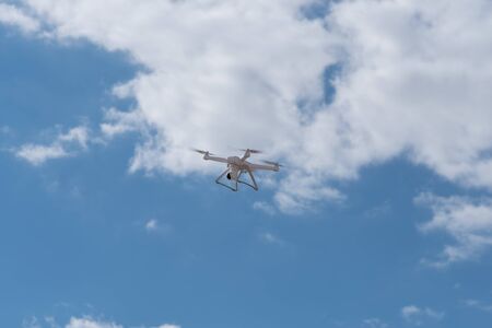 Quadcopter, drone, copter, unmanned aircraft system is flying in the blue sky. Modern video and aerial photographyの写真素材