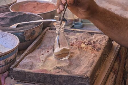 Making souvenirs from colored sand in Petra, Jordan. Life of the local population. Folk and...