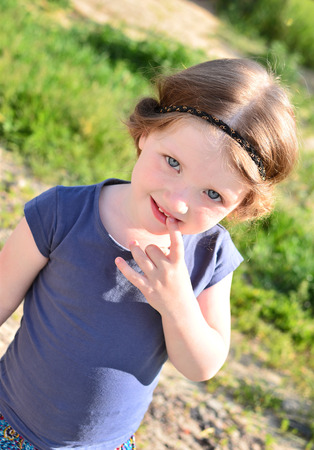 Shy little girl with greek hairstyle in the streetの写真素材