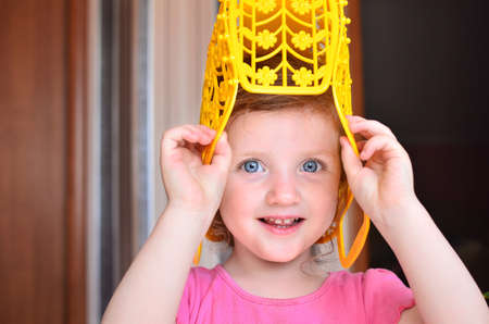 Beautiful girl with large blue eyes playing with toy on her headの写真素材