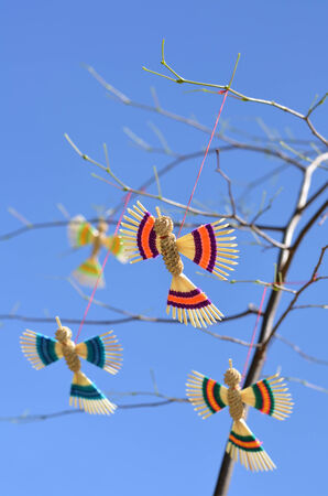 Straw artificial birds hanging by a threadの写真素材