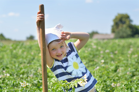 Cute girl resting in potato fieldの写真素材