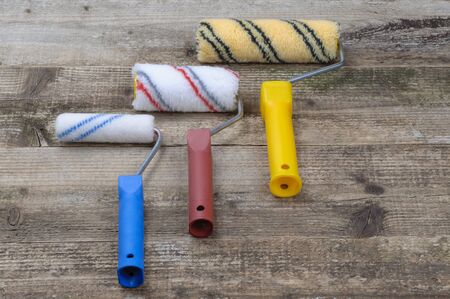 Paint rollers. Construction tool for painting. On a wooden background. Close-up.