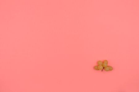 White grapes on a pink background. The angular arrangement of berries. Organic food. Background mode.の写真素材