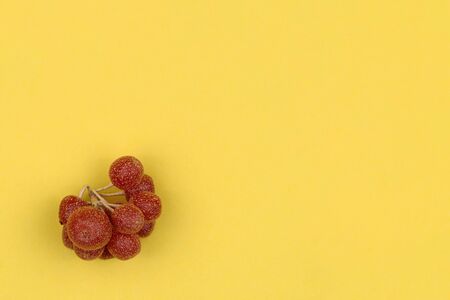Bunch of the red sea-buckthorn on a yellow background.