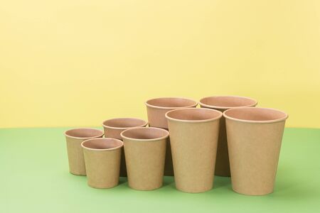 Paper cups in yellow and green background. Ecological utensils.の写真素材