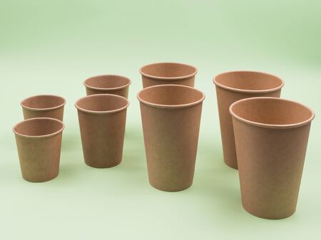Paper cups on a green background. Different sizes. Disposable ware.の写真素材