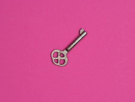 Old key on a pink background. The view from the top.の写真素材