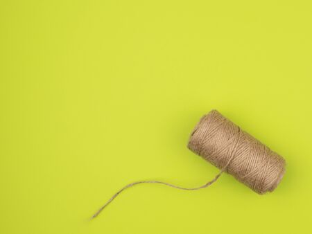 Coil of jute rope on a green background. The view from the top.
