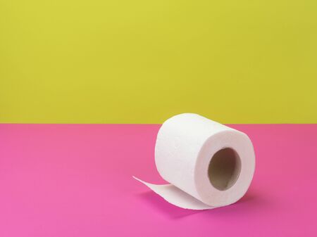 Toilet paper in bright pink and yellow background.