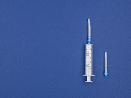 The syringe and needle on a blue background. The view from the top.の写真素材