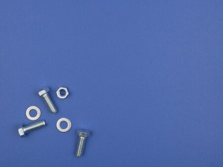 Bolts, nuts and pucks  for fastening on a blue background. The view from the top.