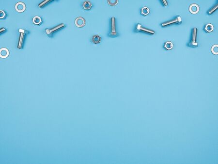 Bolts, nuts and other accessories on a blue background. The view from the top.