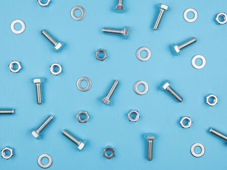 Fastening elements on a blue background. The view from the top. The bolts and nuts.
