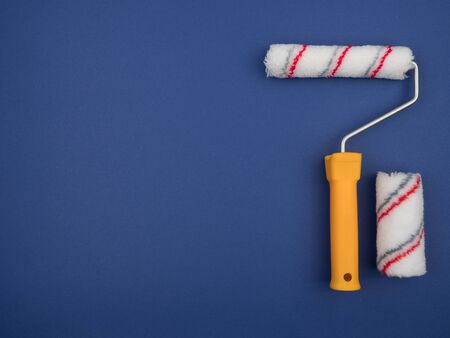 Paint rollers of different sizes on blue background. The view from the top.の写真素材