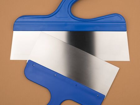Plasterer spatula. Beige background. Building tool. The tool of the painter.