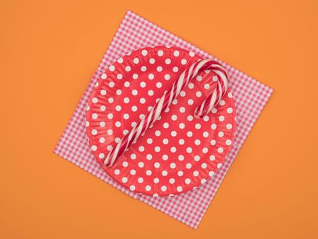 Christmas candy in a dish on a napkin. Orange background.の写真素材