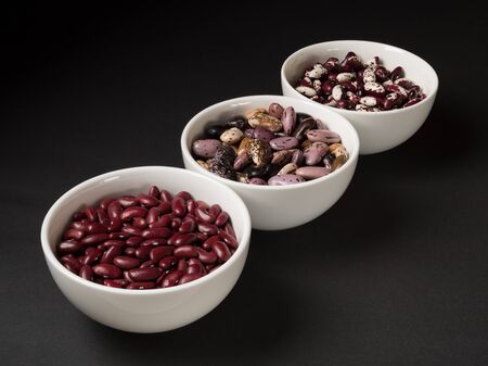 Organic beans and legumes on a black background.