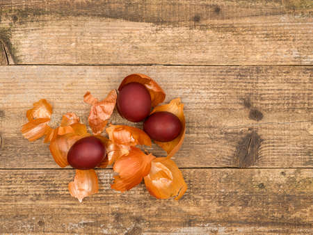 Painted eggs and onion husks on a wooden background.の写真素材