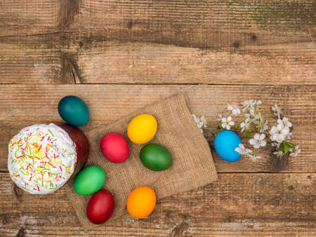 Easter cake and painted eggs on a wooden background.の写真素材