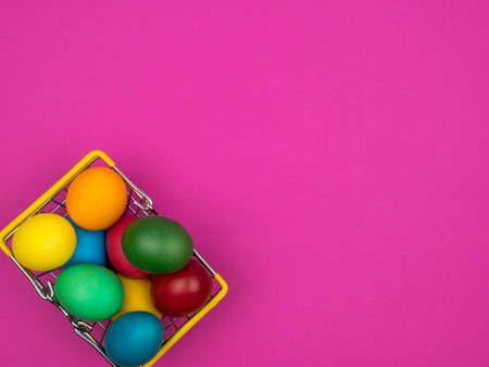 Easter eggs in a metal basket. Bright pink background.の写真素材