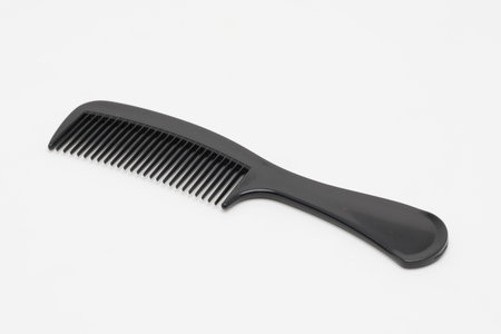 A black plastic comb on a white background.の写真素材