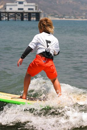 Little boy surfing in Malibu Beach, California