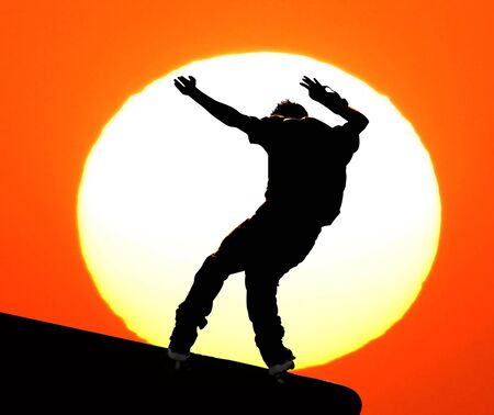 Male skateboarder jumps on a concrete edge at a skateboard park. の写真素材