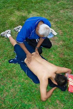 Sports doctor performs massage in the soccer fieldの写真素材