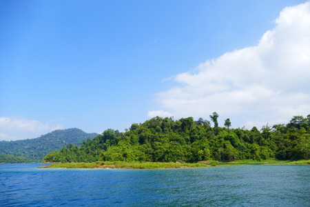 photo picture of a beautiful sea and ocean view with a natural background of rocks, forests and mountains.の写真素材