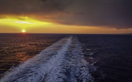 Sunset in the wake of a cruise ship.の写真素材