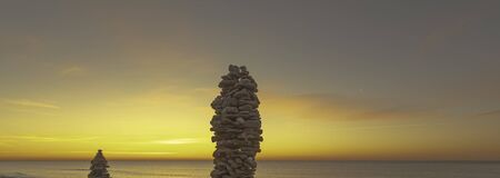 Stack of pebbles on a beach at sunset, Zen atmosphere.の写真素材