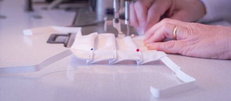 Manufacture of washable masks for facial protection against covid-19 virus, coronavirus, allergy, epidemic and global pandemic.の写真素材