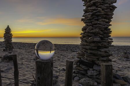 Stack of pebbles on a beach at sunset, Zen atmosphere.