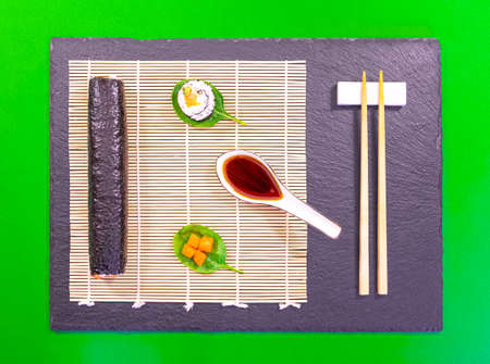 Presentation of Japanese cuisine dish, sushi and maki on black background with soy sauce and chopsticks.の写真素材