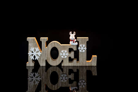 Wooden Christmas decorations with black reflection and space for text.の写真素材