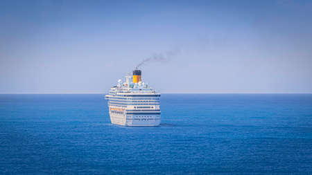 Cruise ship sailing on the blue sea towards the horizon.の写真素材