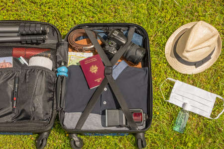 Suitcase on wheels for traveling with mask for face protection and hydroalcoholic gel to fight against the virus, allergy, epidemic and pandemic.のeditorial素材