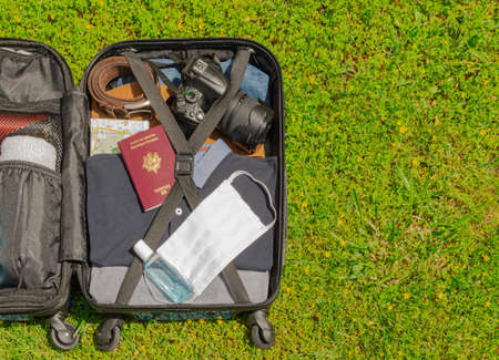 Suitcase on wheels for traveling with mask for face protection and hydroalcoholic gel to fight against virus, allergy, epidemic and pandemic.のeditorial素材