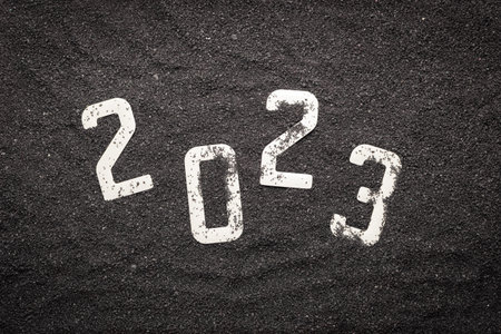 Happy new year 2023 concept with seashell and starfish on black beach sand. Winter vacation in the...