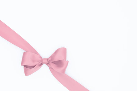 Satin ribbon bow for gift in pink color, isolated on white background.の写真素材