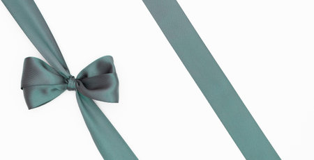 Satin ribbon bow for gift package in green color, isolated on white background. Background with...