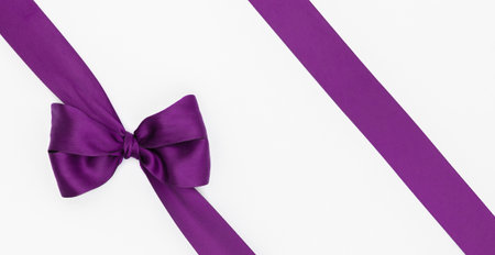 Purple satin ribbon with bow on white background, top viewの写真素材
