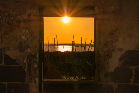 Sunset through the window of a house in the middle of the fieldの写真素材