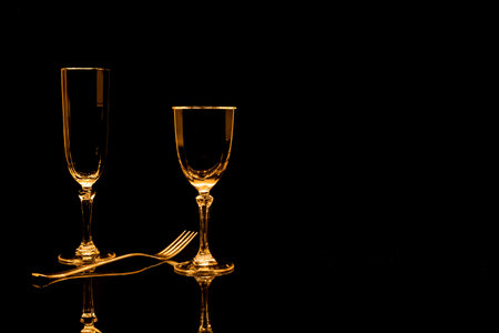 Two wineglasses on a black and white marble background with reflectionの写真素材